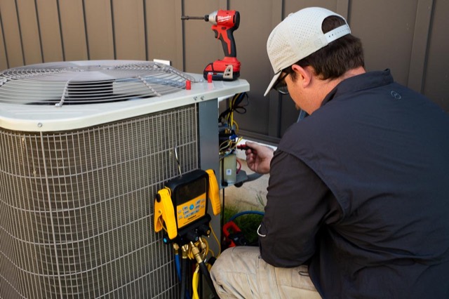 Clark technician diagnosing an AC condenser unit
