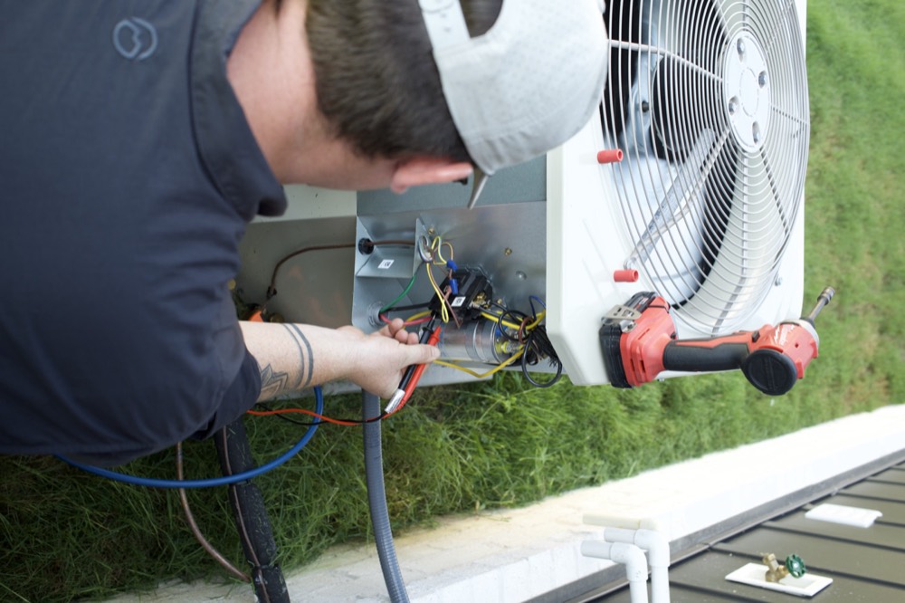 Clark technician testing the electrical components of an outdoor AC unit