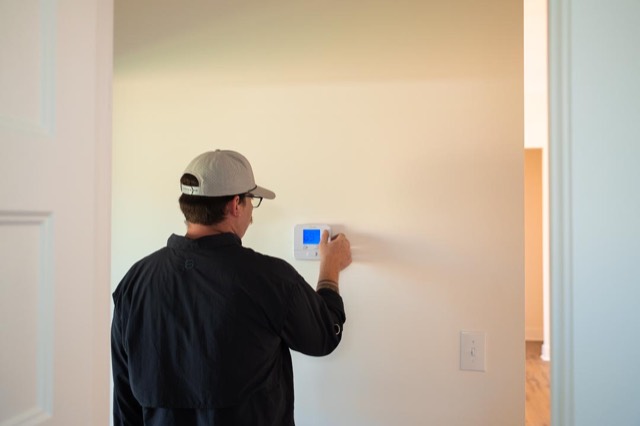 Clark technician setting the thermostat in a comfortable home